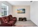 Inviting living room features a plush, reclining sofa, stylish accent wall, and modern decor that create a cozy and relaxing space at 3099 Ella Way, St Cloud, FL 34771