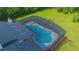 Aerial view of a private screened-in pool and home, showcasing the roof and landscaping at 3160 Whisper Wind Dr, St Cloud, FL 34771