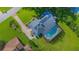 An aerial view of the home with a screened pool and well-manicured backyard and landscaping at 3160 Whisper Wind Dr, St Cloud, FL 34771