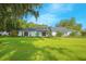 Stunning ranch-style home featuring a manicured lawn, a white brick facade, and mature landscaping at 3160 Whisper Wind Dr, St Cloud, FL 34771