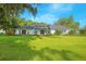 Stunning single-story home featuring a lush green lawn and mature landscaping at 3160 Whisper Wind Dr, St Cloud, FL 34771