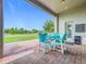Covered outdoor patio with blue table and chairs, overlooking large backyard at 31980 Geoff Way, Sorrento, FL 32776
