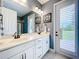Stylish bathroom with double sinks, granite countertop, and access door to the backyard at 31980 Geoff Way, Sorrento, FL 32776