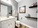 Bathroom featuring a vanity, wall decor, toilet, dark fixtures, and wood-look floors at 31980 Geoff Way, Sorrento, FL 32776