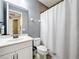 Clean bathroom featuring a single sink vanity, toilet, and shower with white shower curtain at 31980 Geoff Way, Sorrento, FL 32776