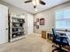 Neutral bedroom with a ceiling fan, a white bookcase and a desk near the window at 31980 Geoff Way, Sorrento, FL 32776
