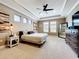 A spacious bedroom with carpet, a tray ceiling, a ceiling fan, a mirror, and three windows at 31980 Geoff Way, Sorrento, FL 32776