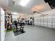 Spacious garage with epoxy flooring and a variety of gym equipment at 31980 Geoff Way, Sorrento, FL 32776