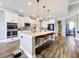 Bright kitchen features a large island with seating, stainless steel appliances, and pendant lighting at 31980 Geoff Way, Sorrento, FL 32776