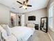 Spacious main bedroom with a ceiling fan, television, walk-in closet, and ensuite bathroom at 31980 Geoff Way, Sorrento, FL 32776