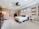 Relaxing main bedroom featuring a ceiling fan, comfortable chair, and bedside table with lamp at 31980 Geoff Way, Sorrento, FL 32776