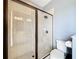 Modern bathroom shower with clear glass door, showerhead and a view of the toilet and vanity at 31980 Geoff Way, Sorrento, FL 32776