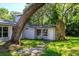 Exterior view of home with stone chimney detail and mature trees at 370 Hand Ave, Ormond Beach, FL 32174