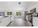 Sunlit kitchen with stainless steel appliances, granite countertops, and backyard views from large windows at 370 Hand Ave, Ormond Beach, FL 32174