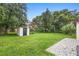 Spacious backyard with lush lawn, mature trees, and a storage shed at 3702 Starks St, Orlando, FL 32805