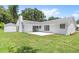 Spacious backyard featuring a well-kept lawn, a white chimney, and a white storage shed at 400 Timbercreek N Dr, Winter Garden, FL 34787