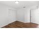 Bright bedroom featuring wood-look floors, a closet with louvered doors, and crisp, white walls at 400 Timbercreek N Dr, Winter Garden, FL 34787