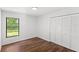 Bedroom featuring wood floors, a window, and a double-door closet at 400 Timbercreek N Dr, Winter Garden, FL 34787