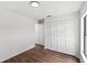 Bright bedroom featuring wood-look floors, a closet with louvered doors, and crisp, white walls at 400 Timbercreek N Dr, Winter Garden, FL 34787