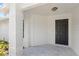 Stylish gray front door with brick pillars on a charming home entrance at 400 Timbercreek N Dr, Winter Garden, FL 34787