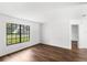 Bright living room featuring dark wood floors, white walls, and a large window with a view of the front yard at 400 Timbercreek N Dr, Winter Garden, FL 34787