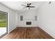 Bright living room featuring a painted brick fireplace, wood floors, and ceiling fan at 400 Timbercreek N Dr, Winter Garden, FL 34787