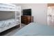 Bedroom with a full bed, bunk bed, dresser, and a mounted television at 4151 S Atlantic Ave # 5110, New Smyrna Beach, FL 32169