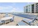 Exterior view of shuffleboard court at condo complex, featuring outdoor tables and lounge chairs at 4151 S Atlantic Ave # 5110, New Smyrna Beach, FL 32169
