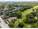 Stunning aerial view of a red-tiled roof house with a pool next to a lush golf course in a beautiful, green neighborhood at 538 W Par St # 538, Orlando, FL 32804
