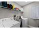 Bright laundry room equipped with side-by-side washer and dryer, storage shelves, and a window at 538 W Par St # 538, Orlando, FL 32804