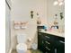 Bathroom with marble-look tile, black vanity, toilet, and decorative frog accents at 545 Mystic Wood St, Casselberry, FL 32707