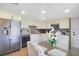 A well-lit kitchen featuring stainless steel appliances and a glass dining table with upholstered chairs at 545 Mystic Wood St, Casselberry, FL 32707