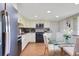 Kitchen featuring white cabinets, black appliances, a glass table with chairs, and wood-look flooring at 545 Mystic Wood St, Casselberry, FL 32707
