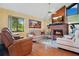 Comfortable living room with a brick fireplace, wood paneling, and bright natural light at 545 Mystic Wood St, Casselberry, FL 32707