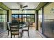 Enclosed sunroom featuring brick floors, ceiling fan, and glass table set for comfortable relaxation and enjoyment at 545 Mystic Wood St, Casselberry, FL 32707