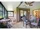 Enclosed sunroom featuring brick floors, ceiling fan, seating area and glass table set for comfortable relaxation at 545 Mystic Wood St, Casselberry, FL 32707