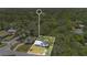 Aerial view of a quaint home with a white roof surrounded by lush tropical landscaping and mature trees at 606 Washington St, Daytona Beach, FL 32114