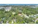 An aerial view of a tan home surrounded by a dense forest of mature trees on a sunny day at 606 Washington St, Daytona Beach, FL 32114