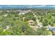 Aerial view of a brown roofed home surrounded by mature trees, and overlooking a blue water view at 606 Washington St, Daytona Beach, FL 32114