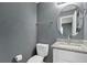 Bathroom features a granite countertop, a round mirror, and a toilet with paper holder at 606 Washington St, Daytona Beach, FL 32114