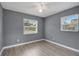 This bedroom offers natural light, wood floors, a ceiling fan, and neutral gray walls at 606 Washington St, Daytona Beach, FL 32114