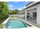 Stunning backyard featuring a modern pool with a water feature, covered patio, and lush landscaping at 617 Worthington Dr, Winter Park, FL 32789