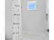 Bright bathroom with a window over the tub and a charming whale-patterned shower curtain at 617 Worthington Dr, Winter Park, FL 32789