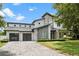 Contemporary home featuring a stone facade, three-car garage, and a well-manicured lawn at 617 Worthington Dr, Winter Park, FL 32789