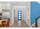 Bright foyer showcasing a modern blue door, sleek hardwood floors, and pristine white walls at 617 Worthington Dr, Winter Park, FL 32789