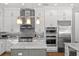 A modern kitchen with stainless steel appliances, white cabinets, and an island with granite countertops at 617 Worthington Dr, Winter Park, FL 32789