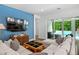Comfortable living room with blue accent wall, plush seating, and sliding glass doors to the patio at 617 Worthington Dr, Winter Park, FL 32789