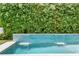 Close up of a pool with a blue tiled waterfall feature and lush green bamboo at 617 Worthington Dr, Winter Park, FL 32789