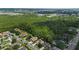 Aerial view of a residential neighborhood with well-maintained homes, mature trees, and a pond at 705 Sunburst Cove Ln, Winter Garden, FL 34787