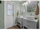 Bathroom featuring double sinks, framed mirrors, and new lighting at 705 Sunburst Cove Ln, Winter Garden, FL 34787